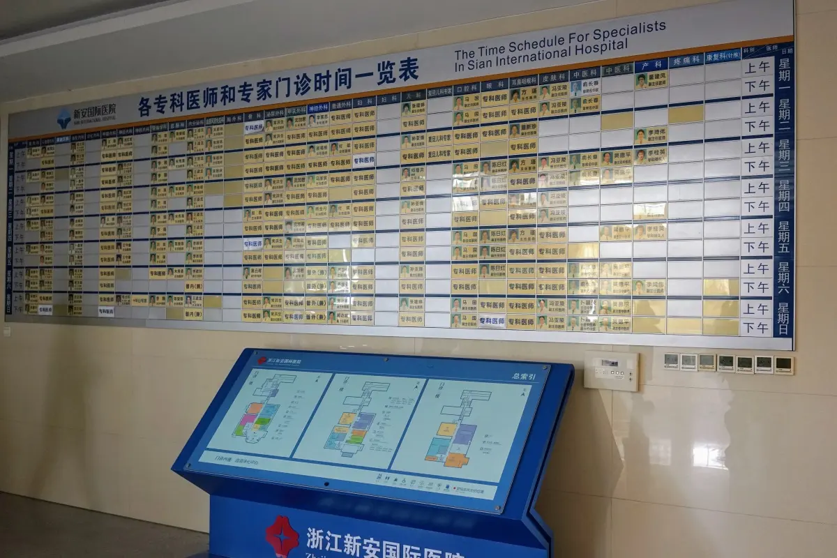Board showing the doctors specialisation and working hours in the lobby of the hospital.
